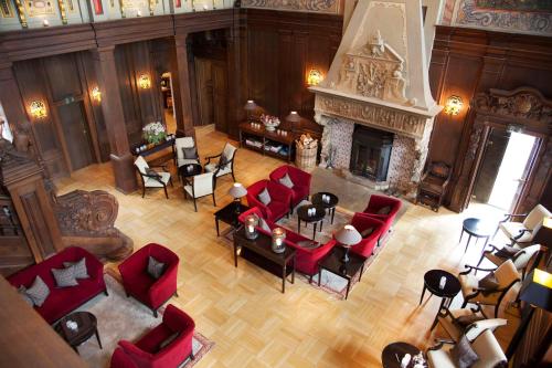 艾珍明希豪森城堡酒店的享有带红色椅子和壁炉的客厅的顶部景色。