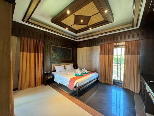 高兰Beach Bungalow at Lanta Resort的一间带一张床铺的卧室,位于带天花板的房间内