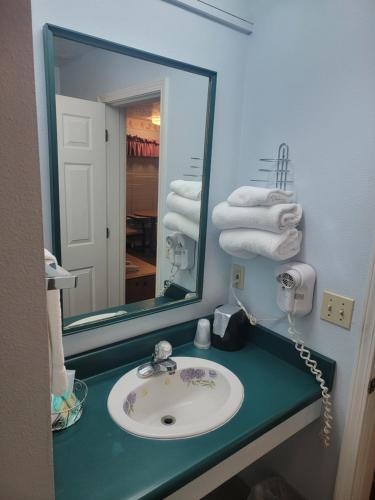 格兰茨帕斯Sweet Breeze Inn的浴室配有盥洗盆、镜子和毛巾