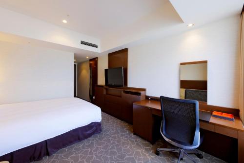 札幌JR札幌日航酒店的酒店客房配有一张床、一张书桌和一台电脑