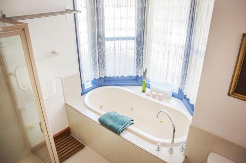 布赖特Artee House - A Bright Escape的带浴缸的浴室和窗户
