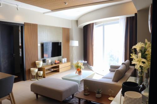 达沃市AEON SUITES STAYCATION managed by ARIA HOTEL的带沙发和电视的客厅