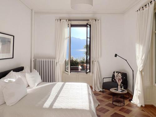 蒙特勒Montreux Luxury Suite的白色的卧室设有床和窗户