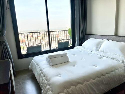 芭堤雅市中心Sea view Pattaya beach @The Base Central Pattaya的配有大窗户的客房内的白色床