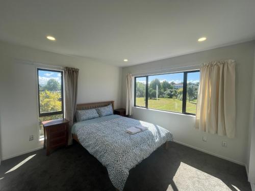 奥克兰Modern Home by the Reserve的一间卧室设有一张床和一个大窗户