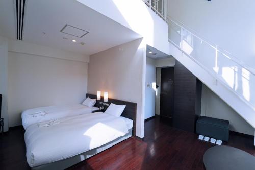仙台KOKO HOTEL Sendai Kotodai Park的一间带两张床的卧室和楼梯