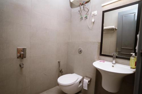 新德里Hotel Lyf Corporate Suites Meera Bagh的一间带卫生间、水槽和镜子的浴室