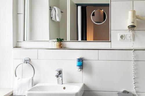 雷根斯堡威登霍夫酒店的白色的浴室设有水槽和镜子