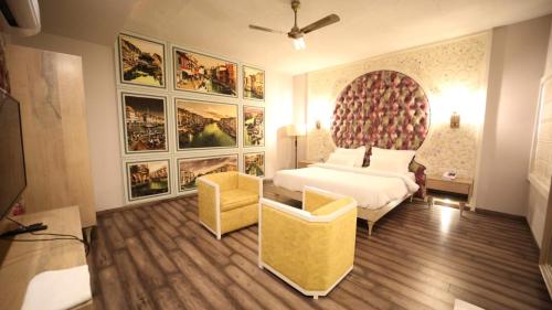 斋浦尔Hotel MEHAI HOUSE的一间卧室配有一张床、一张沙发和绘画作品