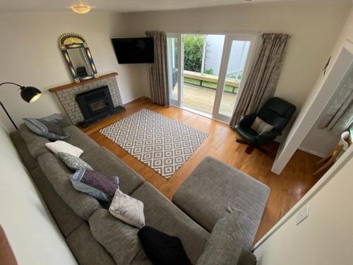 罗托鲁瓦Rotorua Forest Getaway的带沙发和壁炉的客厅