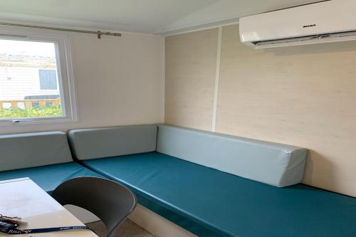 乌伊斯特勒昂Camping Riva Bella的一间设有蓝色长椅和窗户的客房