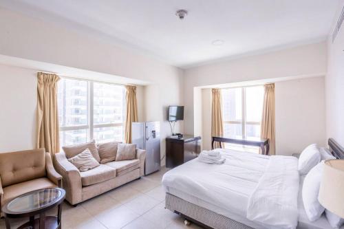 迪拜Marina Marvel - Private Rooms in Shared Apartments Elite Residences的一间卧室配有一张床、一张沙发和一张桌子