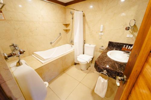 卡兰巴煦日和风温泉度假山庄的一间带水槽、浴缸和卫生间的浴室