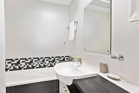 阿布扎比Silkhaus modern 2BDR with pool and gym near Reem Central Park的白色的浴室设有水槽和镜子