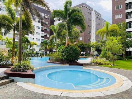 伊洛伊洛Avida Iloilo T3 624的棕榈树公寓大楼内的游泳池