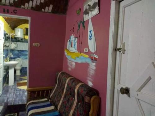 阿斯旺Azoz Nubian House的一间带沙发的粉红色墙壁浴室