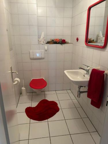 GambarognoAppartamento sul lago的一间带红色卫生间和水槽的浴室