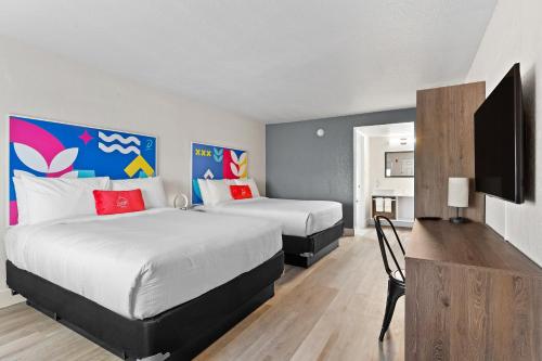 基西米Developer Inn Highway, A Howard Johnson by Wyndham的酒店客房设有两张床和一台平面电视。