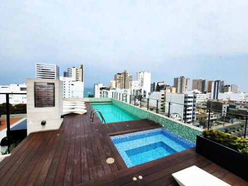 利马Modern 1BR Loft close to the seawalk of Miraflores的建筑物屋顶上的游泳池