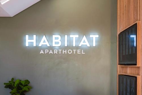 开普敦Habitat Aparthotel by Totalstay的墙上的标志,上面写着人 ⁇ 