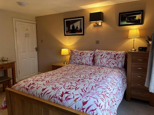 CaenbyThe Old Posthouse B&B的一间卧室配有一张带红色和白色棉被的床