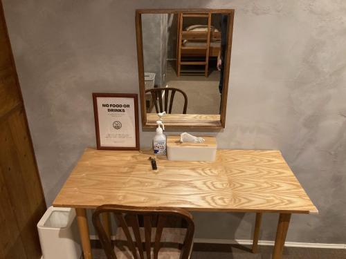 松本Nawate Guesthouse的一张带镜子的桌子和一张桌子,上面有盒子