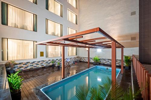 维杰亚瓦达Grand Vijayawada by GRT Hotels的一座带开放式遮阳伞的建筑中的游泳池