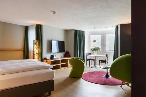 萨尔嫩Seehotel Wilerbad Spa & Seminar的酒店客房配有一张床铺和一张桌子。