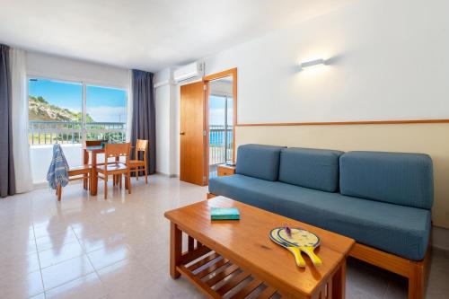 伊维萨镇Apartamentos Vibra Tropical Garden的客厅配有蓝色的沙发和桌子