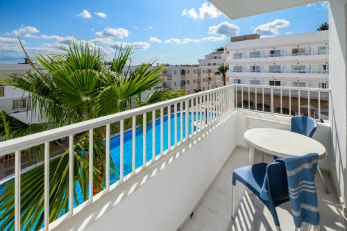 伊维萨镇Apartamentos Vibra Tropical Garden的一个带桌椅的阳台和一个游泳池