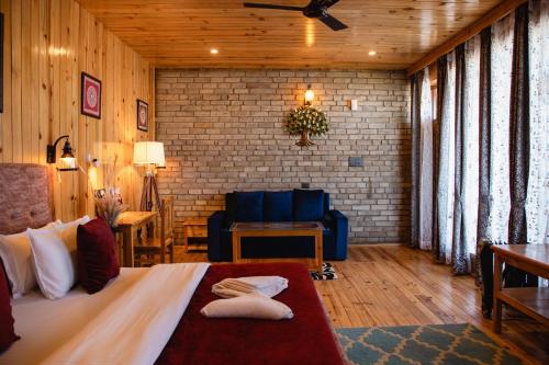 阿尔莫拉Kasar Himalaya Holiday Home, Binsar Rd的一间卧室配有一张床和一个沙发