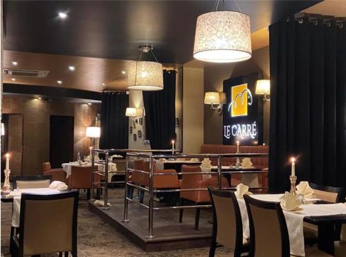 康布雷Logis Hôtel & Restaurant - Le Mouton Blanc的餐厅内带桌椅的用餐室
