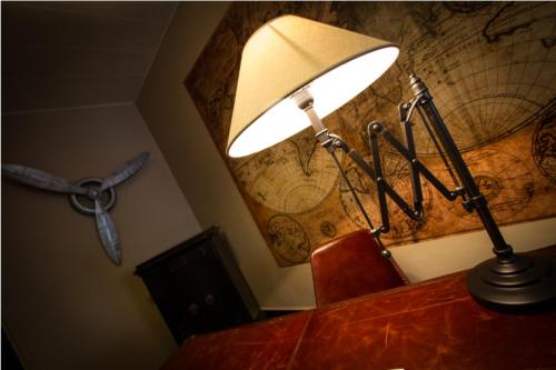 康布雷Logis Hôtel & Restaurant - Le Mouton Blanc的桌子顶上的一盏灯,墙上有球盘