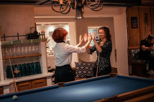 巴特霍夫加施泰因Sendlhofer's的两个女人把手堆在一张台球桌上