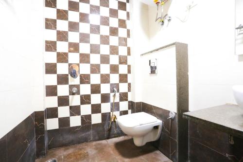 新德里Hotel Aashiyana New Delhi的一间带检查墙和卫生间的浴室