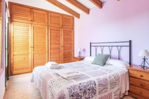 比尼贝卡Es Llaut的一间卧室配有一张大床和木制橱柜。