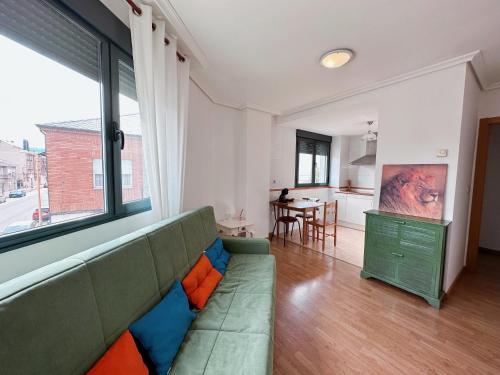 蓬费拉达Suite Rigel的一间带绿色沙发的客厅和一间厨房