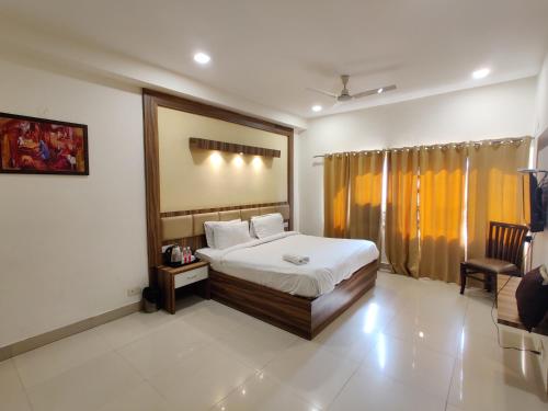 阿姆利则The Raj Darbar A Unit of Arora Hospitality的一间卧室配有一张床和一把椅子