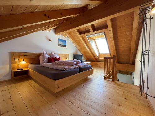 里姆斯廷格See Cafe Toni的一间带一张床的卧室,位于带木制天花板的房间内
