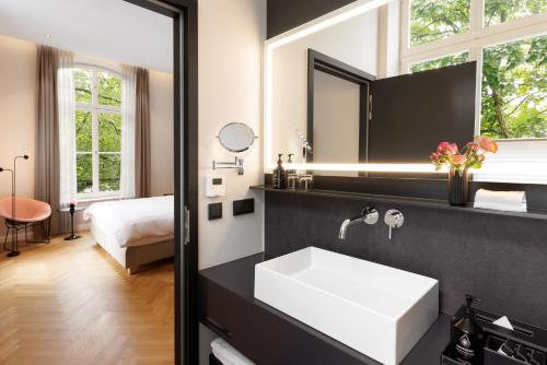 萨尔布吕肯ESPLANADE Saarbrücken的浴室设有白色水槽和镜子