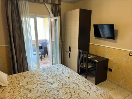 菲乌米奇诺瑞莱别墅酒店的一间卧室配有一张床、一张书桌和一台电视
