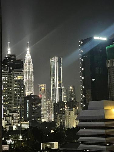 吉隆坡Lazy Apartment KLCC View的城市天际线,夜晚有高楼