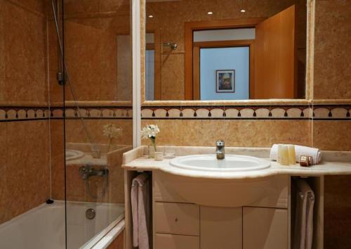 锡切斯锡切斯港酒店的一间带水槽、淋浴和镜子的浴室