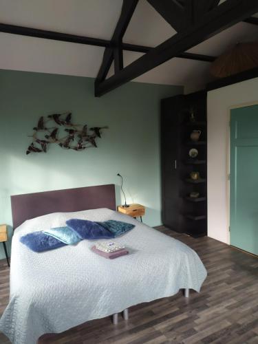 StanddaarbuitenBed and Breakfast Bianca的一间卧室配有带白色床单和蓝色枕头的床。