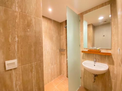 日惹Luxury Malioboro Hotel的一间带水槽和淋浴的浴室