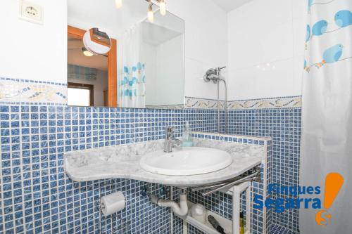 罗达德瓦拉Casa Emporda的浴室配有水槽和蓝色瓷砖墙。