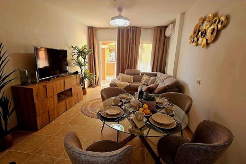 阿罗纳Granada Park Apartament的客厅配有桌椅和电视。