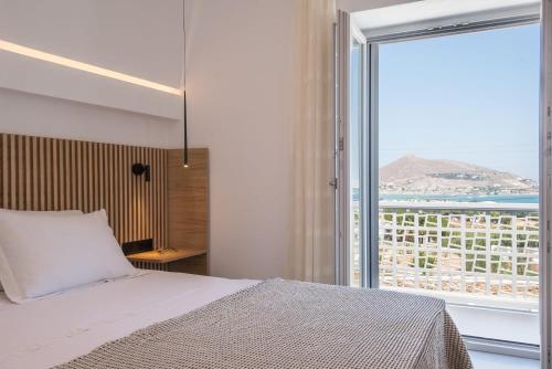莱瓦贾Beautiful Paros Villa - 2 Bedroom - Villa Nirvana - Breathtaking Sea Views and Great for Couples - Naousa的一间卧室设有一张床和一个大窗户