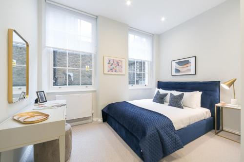 伦敦Urban Chic – Drury的卧室配有一张床、一张书桌和窗户。