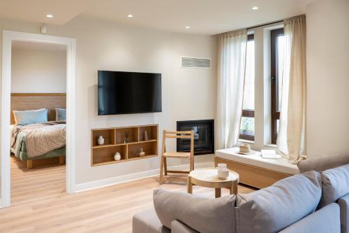 伊里斯斯MAISON - ELEA的客厅配有沙发和墙上的电视